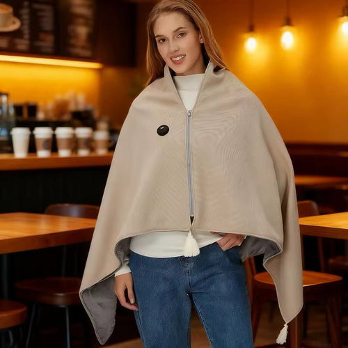 Snuggle Cloak heated hooded sweater worn in a cafe, oat colourway